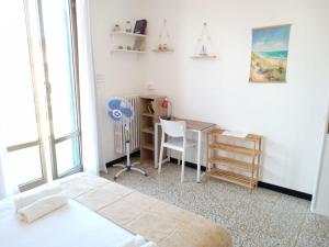ein Schlafzimmer mit einem Bett, einem Schreibtisch und einem Fenster in der Unterkunft L'Attico sul Porto, Sea View with Terrace, Imperia Center in Imperia + 15 Fotos