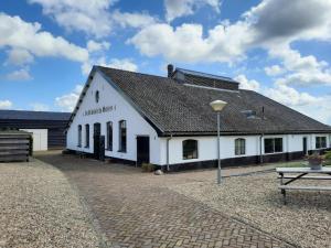 a white building with a black roof at Chalet in Netherlands near Cycling Trails in Beekbergen