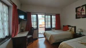 a hotel room with two beds and a window at Mansión de la Bolivia in La Paz