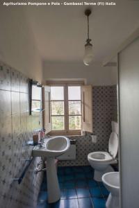a bathroom with two sinks and a toilet and a window at Agriturismo Pompone e Pola in Gambassi Terme +50 photos