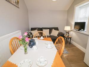 a dining room with a table and chairs and a couch at Ballard Cottage Annexe in Newry