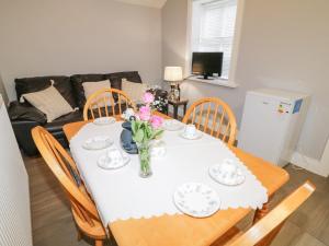 a dining room table with plates and flowers on it at Ballard Cottage Annexe in Newry