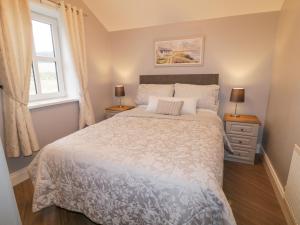 a bedroom with a large bed and two lamps at Ballard Cottage Annexe in Newry