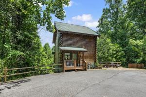 una cabaña de troncos en el bosque con una valla en Black Bear Bungalow by Avada Properties, en Gatlinburg 44 fotos más