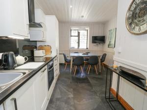 a kitchen with a sink and a table with chairs at Bwthyn y Coediwr The Woodcutters Cottage in Blaenau-Ffestiniog