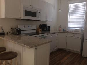 a kitchen with white cabinets and a counter top at The Chorus Frog - 8 Hollow in Cherry Valley