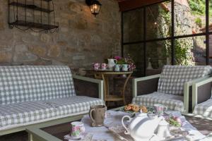 een patio met 2 stoelen en een tafel met een theeset bij Villa Valerie in Cortona