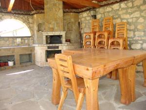 a wooden table and chairs in a room with a fireplace at Morski Briz Houses in Topola