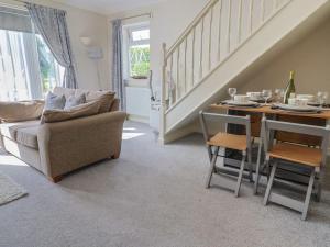 a living room with a couch and a table with chairs at Rosemarie Annexe in Axminster