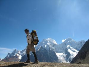 a man with a backpack standing on top of a mountain at Huayhuash Trek - Cuartelhuain Huayllapa 6 days in Huaraz