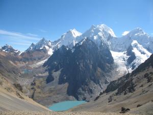 a mountain range with a lake in the foreground at Huayhuash Trek - Cuartelhuain Huayllapa 6 days in Huaraz