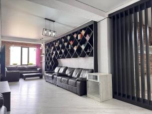 ビシュケクにあるBorsan apartment near park Panfilovの革張りのソファとテーブルのあるリビングルーム