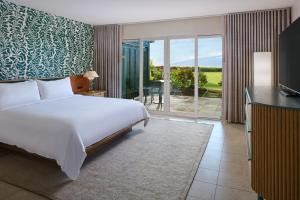 una camera da letto con un letto e una porta scorrevole in vetro di Royal Lahaina Bungalows & Spa a Lahaina