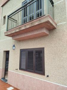 un balcone con una porta marrone e una finestra di Vivienda VACACIONAL LA PASADA a Las Casas