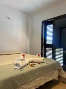 una camera da letto con un letto con asciugamani e fiori di Vivienda VACACIONAL LA PASADA a Las Casas