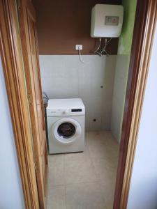 una lavatrice e un'asciugatrice in un piccolo bagno di Vivienda VACACIONAL LA PASADA a Las Casas Altre 4 foto