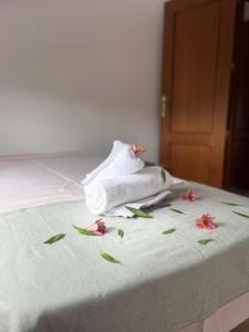 un mucchio di asciugamani e fiori su un letto di Vivienda VACACIONAL LA PASADA a Las Casas