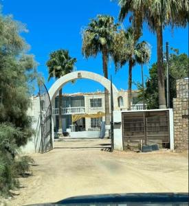 a gate in front of a house with palm trees at Shoreline Condo 4 Desert Oasis Free Wifi, Cool AC in San Felipe