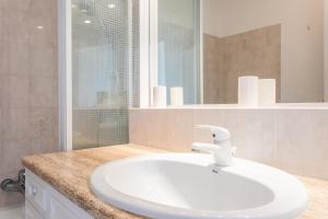 a bathroom with a white sink and a mirror at Appartement cocooning in Fréjus +16 photos