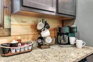 a kitchen counter with pots and pans and a coffee maker at Bear Up There Cabin by Avada Properties in Pigeon Forge