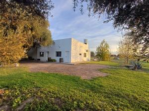 a white building with a yard in front of it at Departamento Tranquilidad y descanso in General Alvear