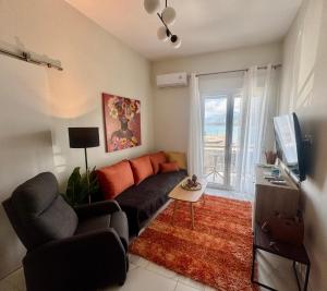 a living room with a couch and a tv at Aquamarine - Beach Flat in Itea