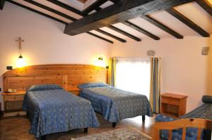 a bedroom with two beds and a cross on the wall at Hotel Vittoria in Riva del Garda +37 photos