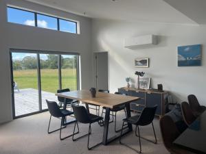 a dining room with a table and chairs at Clifton Bay Cottage in Te Awanga