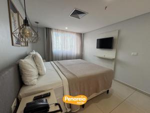 a hotel room with a bed and a television at IMPERIAL TAMBAU Flat by PenareiaTurBr in João Pessoa