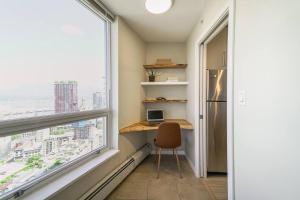 Un pequeño escritorio en una habitación con una ventana grande. en Gorgeous Water View Unit in Downtown Vancouver, en Vancouver