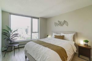 Un dormitorio con una cama grande y una ventana grande. en Gorgeous Water View Unit in Downtown Vancouver, en Vancouver