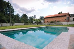 una piscina nel cortile di una casa di Entorno rural con piscina by CABANA Rentals a Budiño
