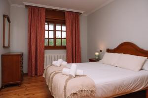 una camera da letto con un letto con lenzuola bianche e una finestra di Entorno rural con piscina by CABANA Rentals a Budiño Altre 32 foto