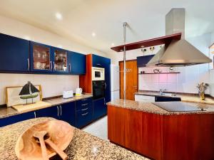 a kitchen with blue cabinets and a counter top at By the Sea Mindelo Pool House in Vila Chã
