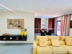 a living room with a yellow couch and a table at By the Sea Mindelo Pool House in Vila Chã