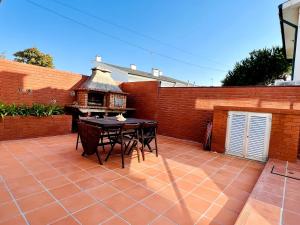 a patio with a table and chairs and a brick wall at By the Sea Mindelo Pool House in Vila Chã