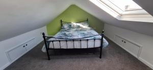 a bedroom with a bed with a green wall at Modern 3 bedroom 2 bathroom Free Wifi Central Location in Middlesbrough