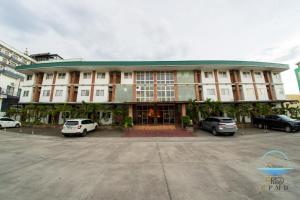 a large building with cars parked in a parking lot at CJ by the Bay in Olongapo