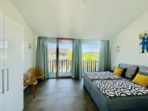 a bedroom with a bed and a balcony at Architektenhaus c5 mit Seesicht in Öhningen