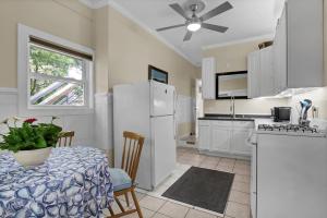 a kitchen with a table and a white refrigerator at Higher Altitude | Cozy Downstairs Apt. Close to the Beach in Surf City, NC in Sloop Point