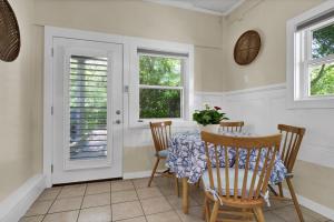 a dining room with a table and chairs and two windows at Higher Altitude | Cozy Downstairs Apt. Close to the Beach in Surf City, NC in Sloop Point +16 photos