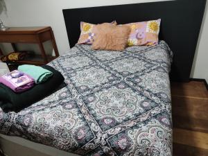 a bed with a comforter and pillows on it at Pousada Canto dos Pássaros in Cianorte