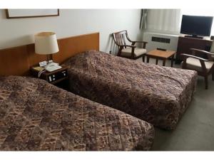 une chambre d'hôtel avec deux lits et une télévision dans l'établissement Kitaguni Grand Hotel - Vacation STAY 97210v, à Oshidomari