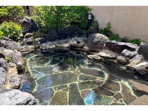 une piscine d'eau avec des rochers dans un jardin dans l'établissement Kitaguni Grand Hotel - Vacation STAY 97231v, à Oshidomari 6 autres photos