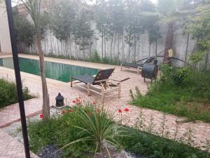 a patio with a bench and a swimming pool at Villa tagmouti in Aghmat