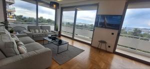 a living room with couches and a flat screen tv at Vip Panoramic view in Athens