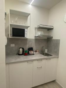 a white kitchen with a sink and a microwave at Da Mariolino in Arezzo