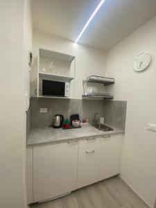 a white kitchen with a sink and a microwave at Da Mariolino in Arezzo +11 photos