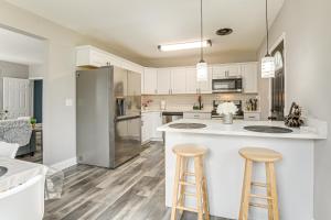 a kitchen with white cabinets and bar stools at 4 Mi to Universities Quaint Parkville Apartment! in Parkville