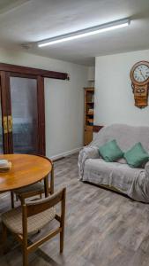 a room with a bed and a table and a clock at Y Fedw Wen in Bont Newydd +35 photos